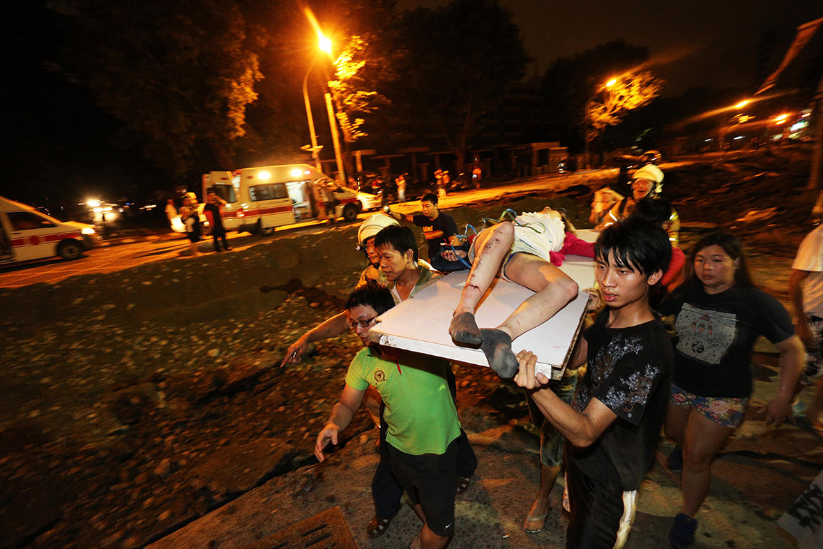 Residents carry a wounded person following a blast in the city of Kaohsiung in southern Taiwan