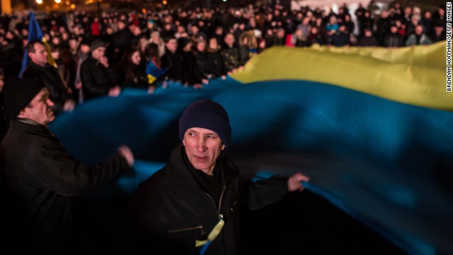 People wave a large Ukrainian flag in Independence Square on Sunday, February 23.