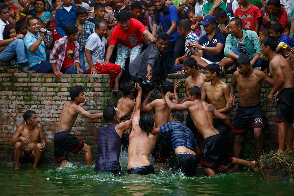 The winning team retrieves a goat from the water during the Deopokhari festival in Khokana. During the annual festival, a live goat is thrown into a pond and the team of devotees that retrieves the animal first wins