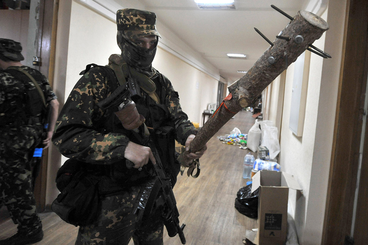 A pro-Russian fighter displays a club in Donetsk's regional state building
