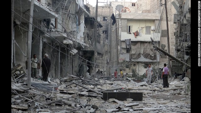 Residents inspect the rubble of destroyed buildings in Aleppo after Syrian regime helicopters allegedly dropped barrel bombs there on Wednesday, August 13.