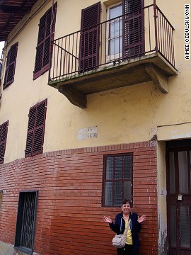 The author's mother stands in front of the house where her grandmother was born. 