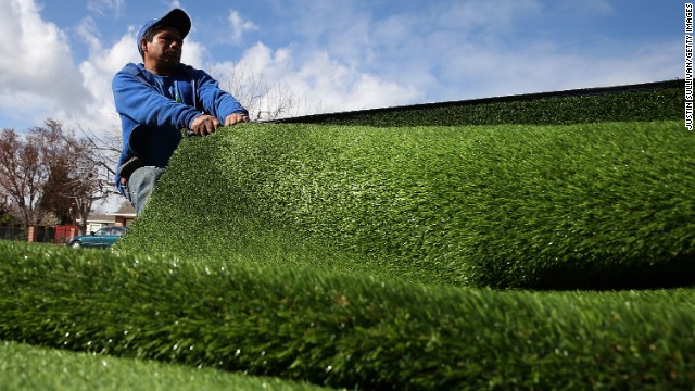 A worker installs an artificial lawn in front of an apartment building in San Jose, California, on January 30.