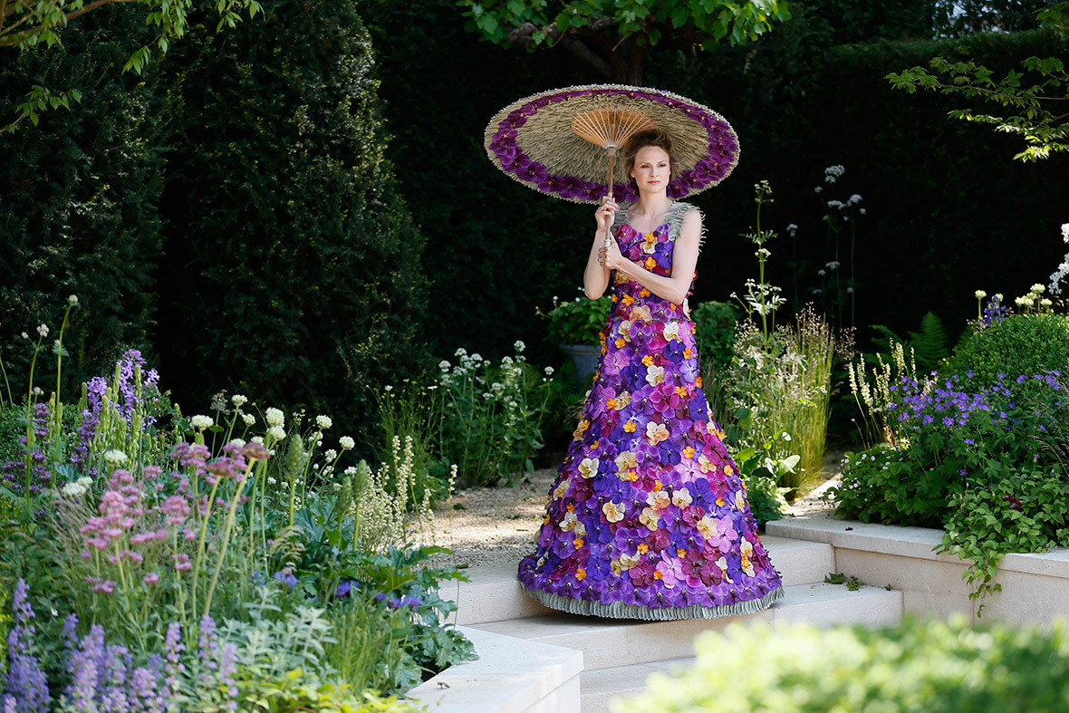 A model wearing a dress made of 1,000 Orchida Vanda petals, designed by Judith Blacklock, poses for photographers in the M & A Garden during media day at the Chelsea Flower Show in London