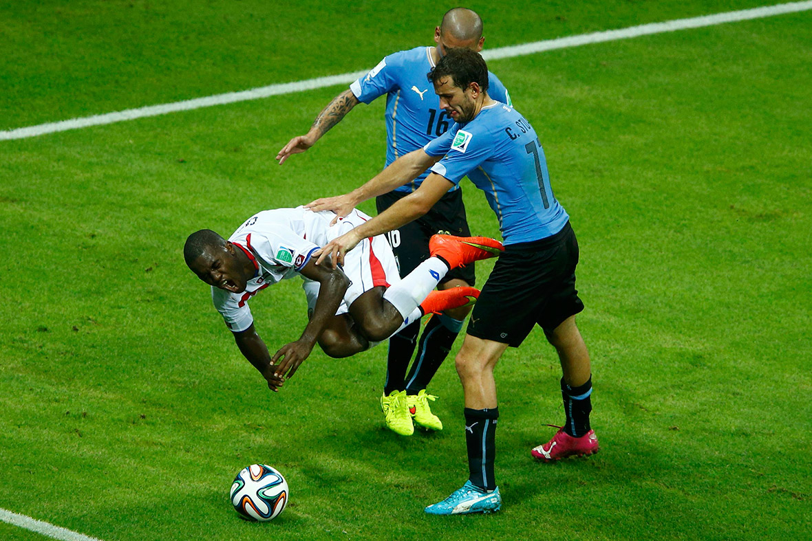 Costa Rica's Joel Campbell is fouled by Uruguay's Maximiliano Pereira next to teammate Christian Stuani during their World Cup Group D match at the Castelao arena in Fortaleza. Pereira was issued a red card for the foul.