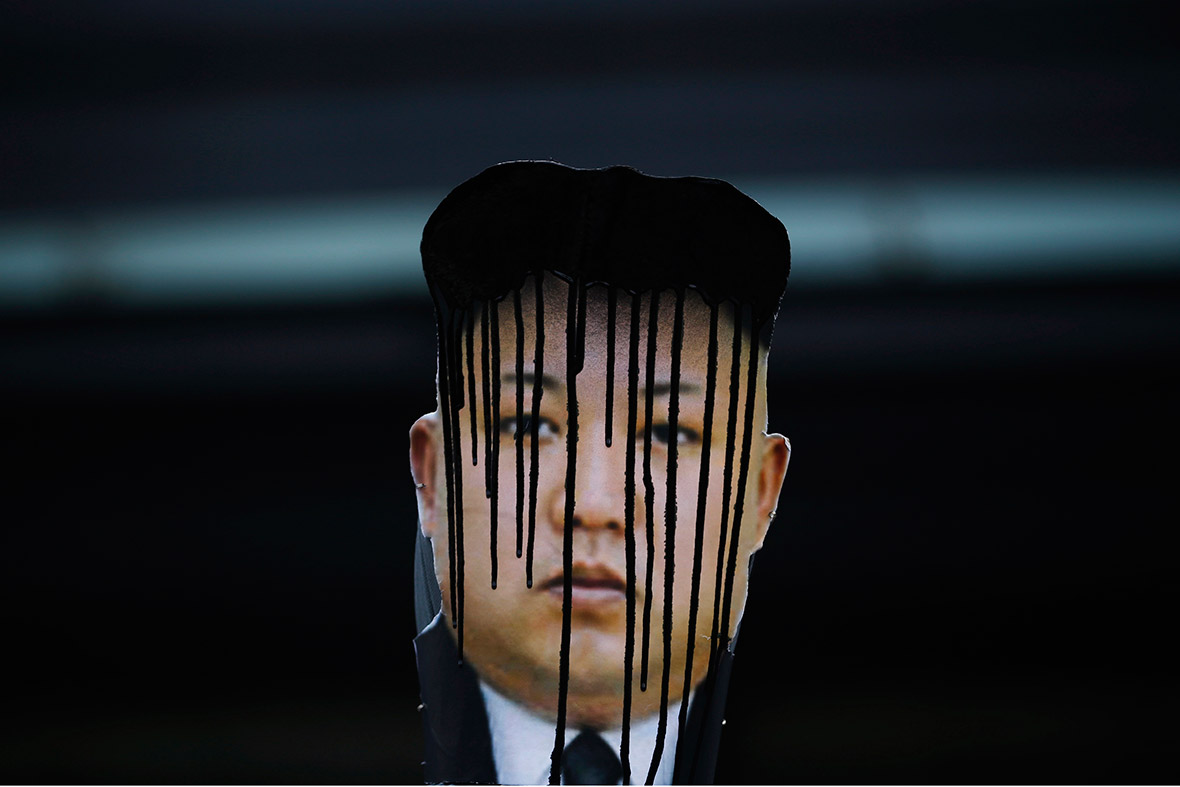 A defaced portrait of Kim Jong-un is seen during an anti-North Korean rally in Seoul, on the 102nd birthday of Kim Il-sung