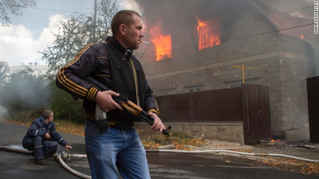 A pro-Russian rebel walks past a burning house after shelling in Donetsk on Sunday, October 5.