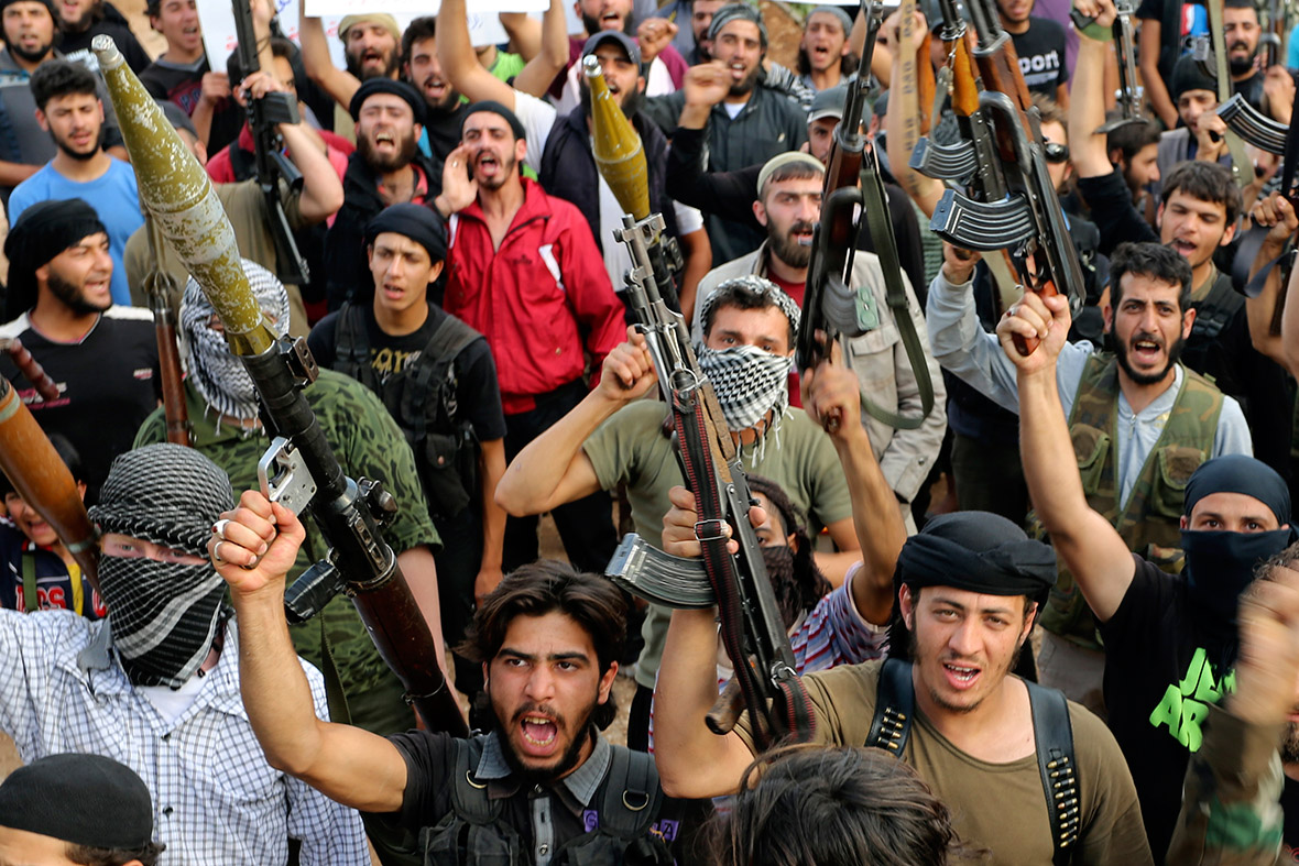 Free Syrian Army fighters hold their weapons during a call for leaders of other military groups to start liberating the city of Hama from forces loyal to Syria's President Bashar al-Assad