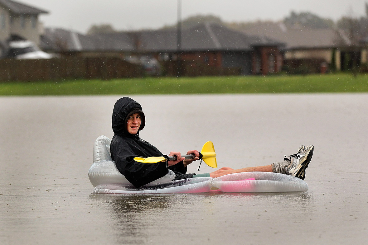 Hamish McEwan, 15, paddles his lilo on a flooded playground in Rangiora after heavy rain in New Zealand.