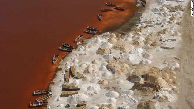 Piles of salt drying on the shores of Lake Retba. The lake's salt content rivals that of the Dead Sea and the combination of the sun and salt-loving micro-algae has given the water its color. 