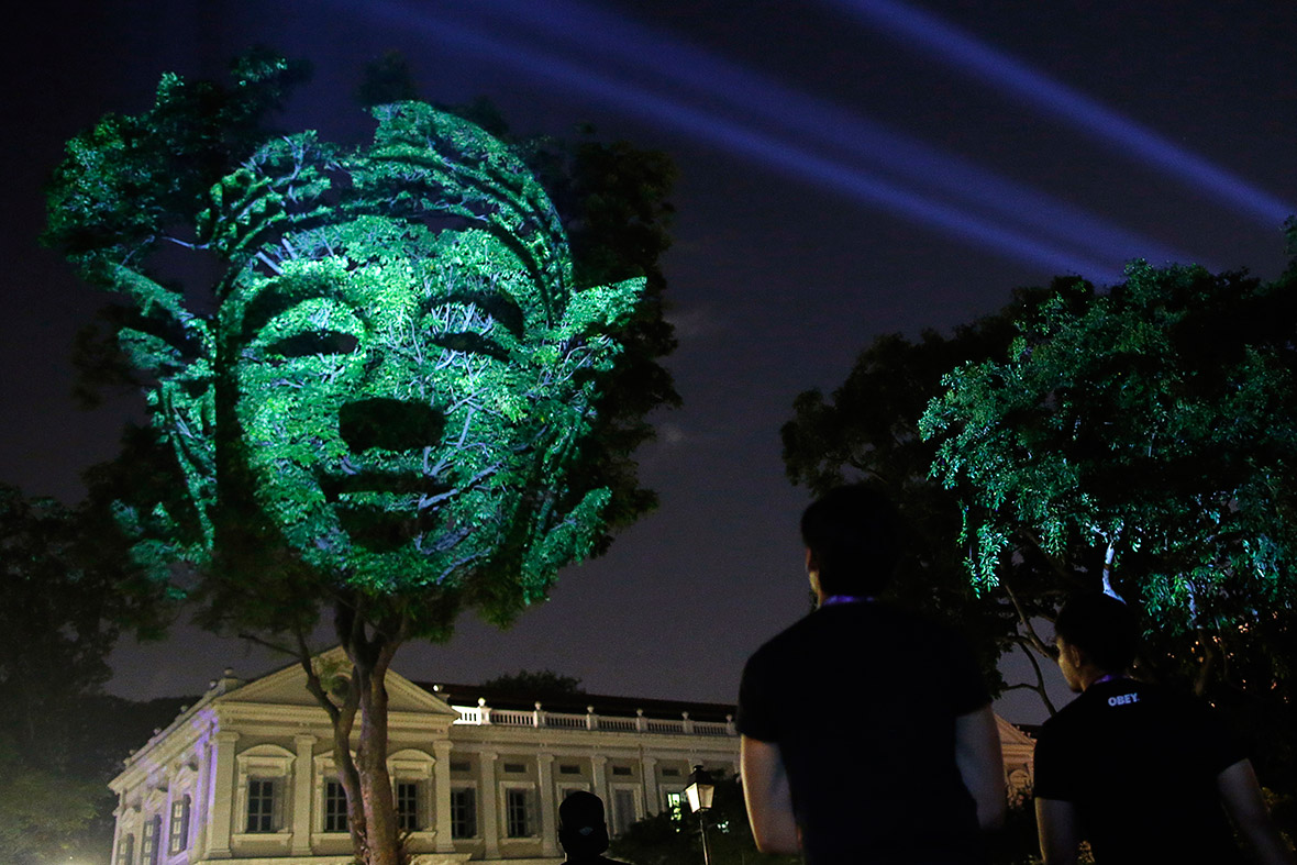 People look at French artist Clement Briend's photographic light installation Divine Trees, which features images of figures highly revered in Asian cultures projected onto trees at the Singapore Night Festival