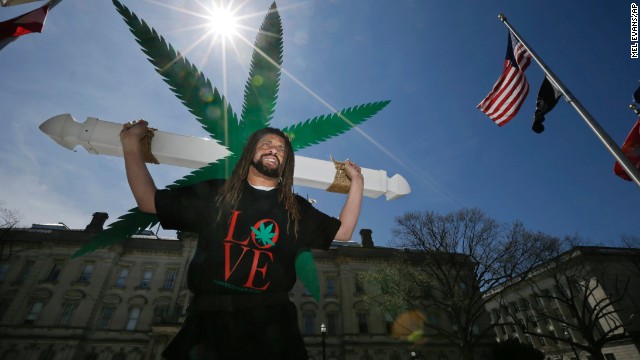 Ed Forchion, a pro-marijuana activist known as NJ Weedman, carries a large cross with huge likeness of a marijuana leaf on April 20 as he walks in front of the New Jersey Statehouse in Trenton, New Jersey. Dozens of activists and community members gathered in front of Statehouse to show their support for legalizing marijuana.