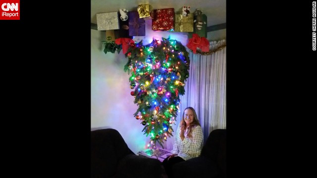 <a href='http://ift.tt/13la6B9'>Sherri Aguilar</a> attaches her inverted Christmas tree to the ceiling with eye bolts and uses a staple gun to put up the gift bags and presents.