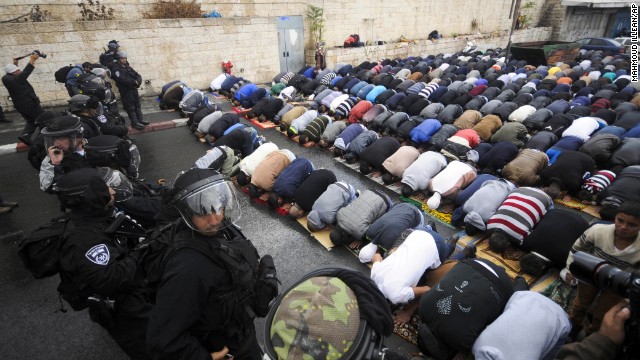 Israeli border police block a road in Jerusalem as Muslims pray Friday, October 31. A day after taking the rare step of closing the Temple Mount holy site, Israel partially reopened access for Muslim prayers Friday. But midday access was granted only to men over 50 and women. Israeli police said this was meant to prevent demonstrations by young Muslim men following the recent shootings of a controversial rabbi and a Palestinian suspect in the rabbi's shooting.