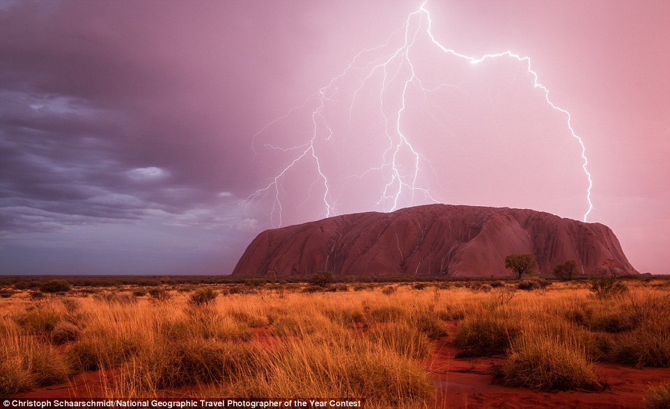 Uluru, or Ayers Rock, is illuminated by several bolts of lightning as a storm rolls through Yulara, Northern Territory, Australia