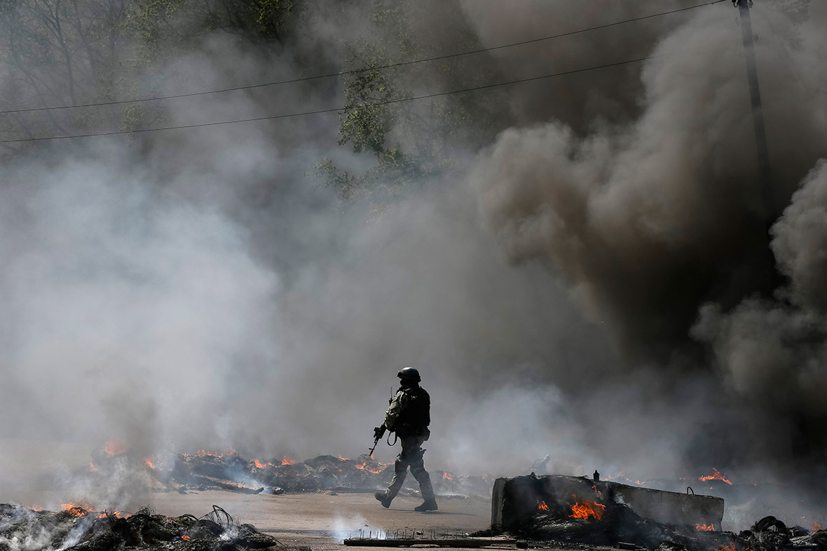 A Ukrainian security force officer is deployed at a checkpoint set on fire and left by pro-Russian separatists near Slaviansk
