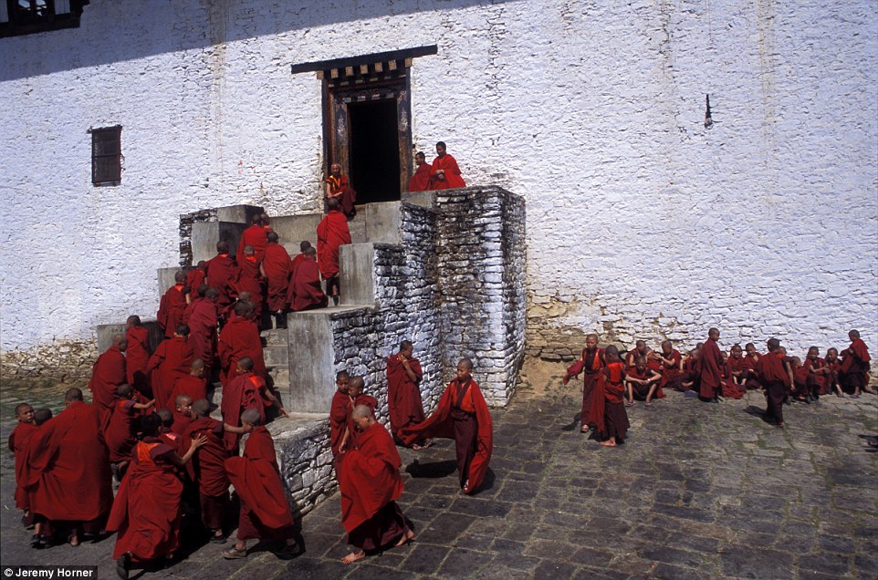 Clothed in vibrant red robes, novice monks return to prayer studies after a break in the courtyard of Semtokha Monastery near Thimphu, Bhutan