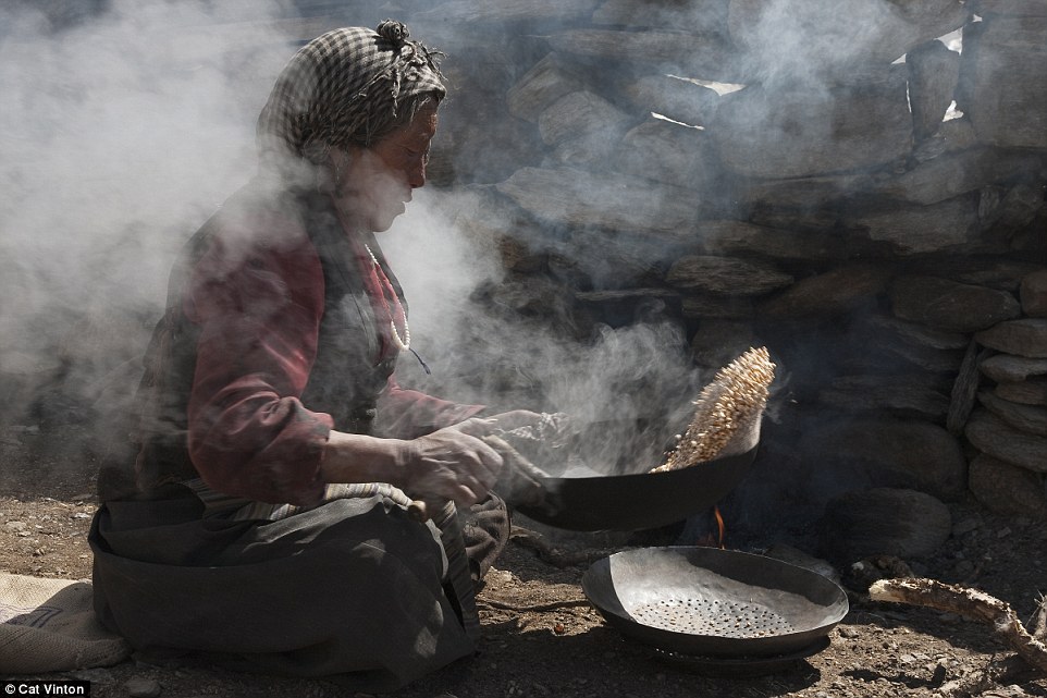 Hands on: Yangyen is pictured here in the early morning making tsampa – a type of Tibetan flour – from roasted barley