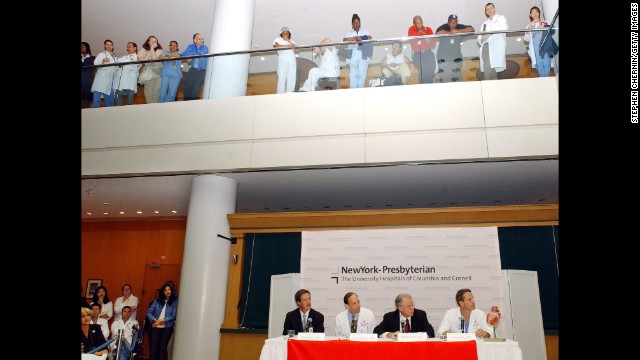 Employees and visitors watch from the balcony as Dr. Craig Smith, lower right, chief of the division of cardiothoracic surgery listens to a reporter's question during a briefing about the status of Clinton's condition after quadruple bypass surgery at New York Presbyterian Hospital on September 6, 2004. Clinton was hospitalized after suffering chest pains and shortness of breath. Doctors announce that some of Clinton's arteries had been blocked more than 90%.