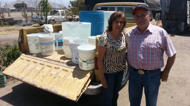 Simona and Adolfo Magaña have no running water; they fill these buckets from a neighbor's tap.