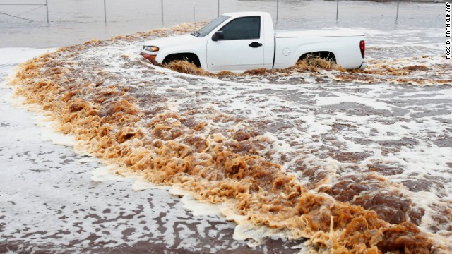 A truck creates a wake as its driver tries to make it through a severely flooded street in Phoenix on Monday, September 8. Arizona's governor declared a statewide emergency as <a href='http://ift.tt/1qxOTNi'>record-setting rains flooded numerous Phoenix-area roadways and forced some schools to shut down.</a>