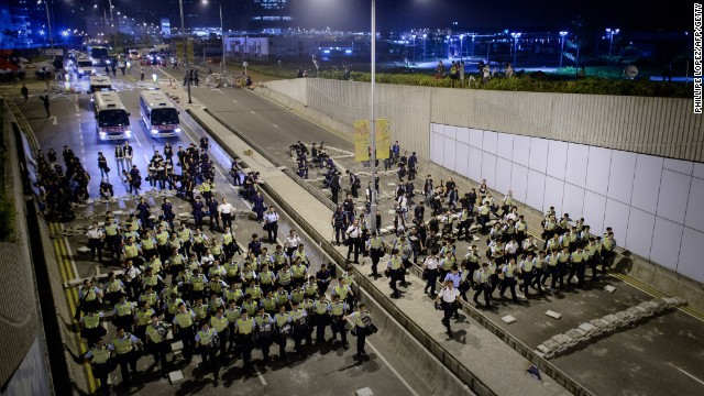 Police forces march toward pro-democracy protesters on a key road outside the central government offices in Hong Kong on October 14.