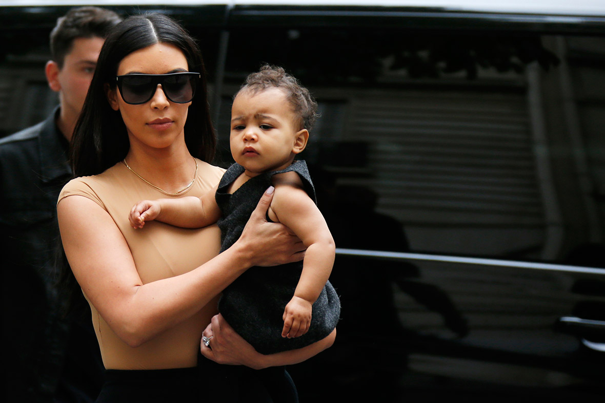 Kim Kardashian holds her daughter North in her arms as she shops in Paris