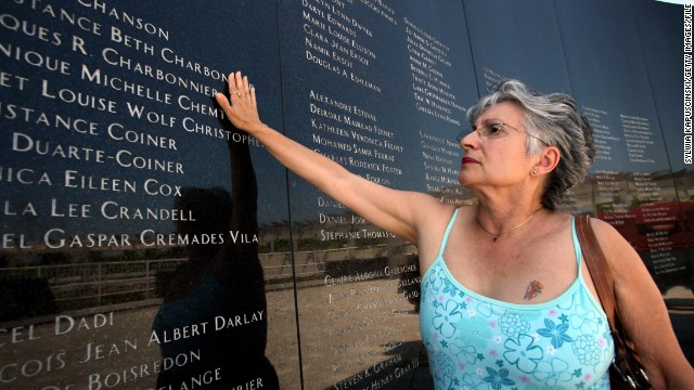 Joanne Festa touches the memorial wall commemorating the victims of TWA Flight 800 on July 16, 2006, at the Smith Point County Park in Shirley, New York.
