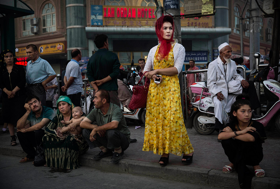 People wait at a bus stop in old Kashgar