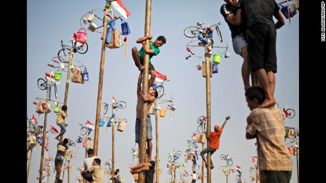 <strong>August 17:</strong> People in Jakarta, Indonesia, struggle to climb greased poles during a competition that was part of the country's Independence Day celebrations.