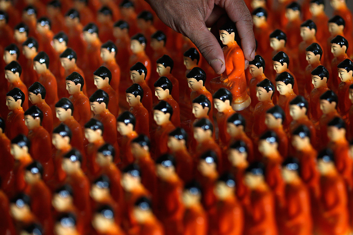 A man packs Buddha figurines at a workshop in Colombo