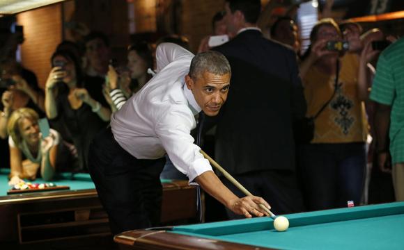 U.S. President Barack Obama shoots pool during a stop in a bar in Denver July 8, 2014. Obama will speak about the economy at an event in Denver tomorrow. REUTERS/Kevin Lamarque