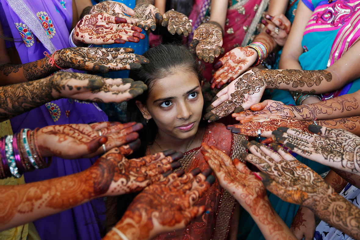 Schoolchildren show their hands decorated with henna during a competition to mark World Population Day in the western Indian city of Ahmedabad.