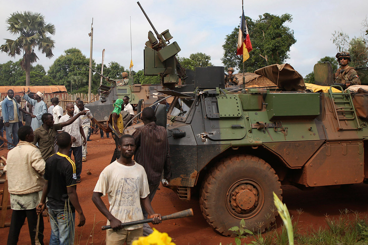 Men argue with French soldiers as they block a road during a protest in Bambari