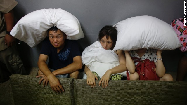 A family from San Jose, California, covers themselves with pillows as they sit in the service area of a Los Cabos resort on September 15.