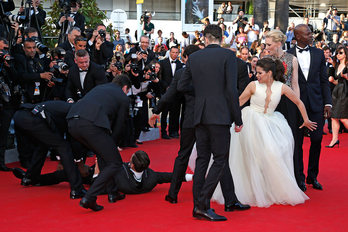 A man is arrested by security as he tries to slip under the dress of America Ferrera on the red carpet for the screening of the film 