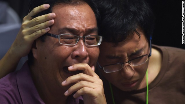 Relatives of missing passengers comfort each other December 30 at Juanda International Airport in Surabaya.
