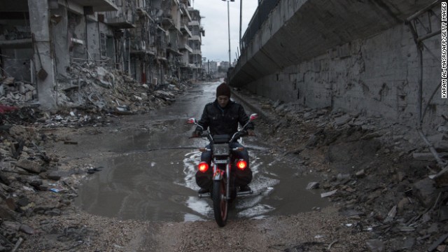 A man drives his motorcycle through a puddle in Aleppo, Syria, on Wednesday, November 26. The United Nations estimates more than 190,000 people have been killed in Syria since an uprising in March 2011 spiraled into civil war.
