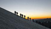 Encolumnados, los montañistas trepan hacia la cumbre. Amanece.