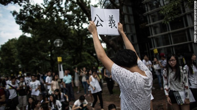 A student holds a poster with the Chinese characters for ''Justice.'' Beijing has said that Hong Kongers may vote for their next leader but candidates must be approved by a small committee.