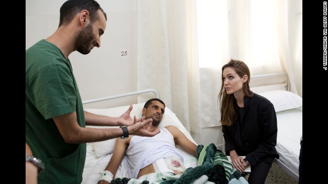 Jolie visits a man in a hospital in Misrata, Libya, in October 2011 in this handout photo provided by UNHCR.