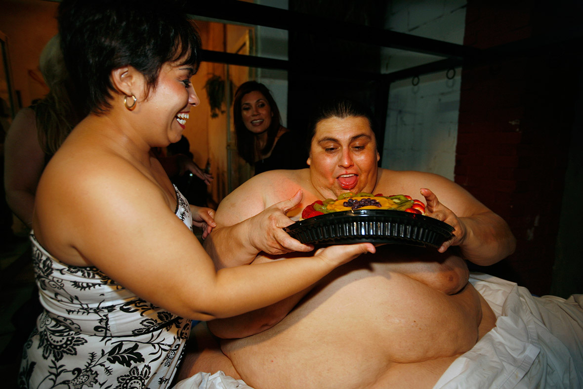June 11, 2008: Manuel Uribe pretends to eat a cake held by his girlfriend Claudia Solis. Uribe, once the world's most obese man, celebrated his 43rd birthday with a very short trip outside his house