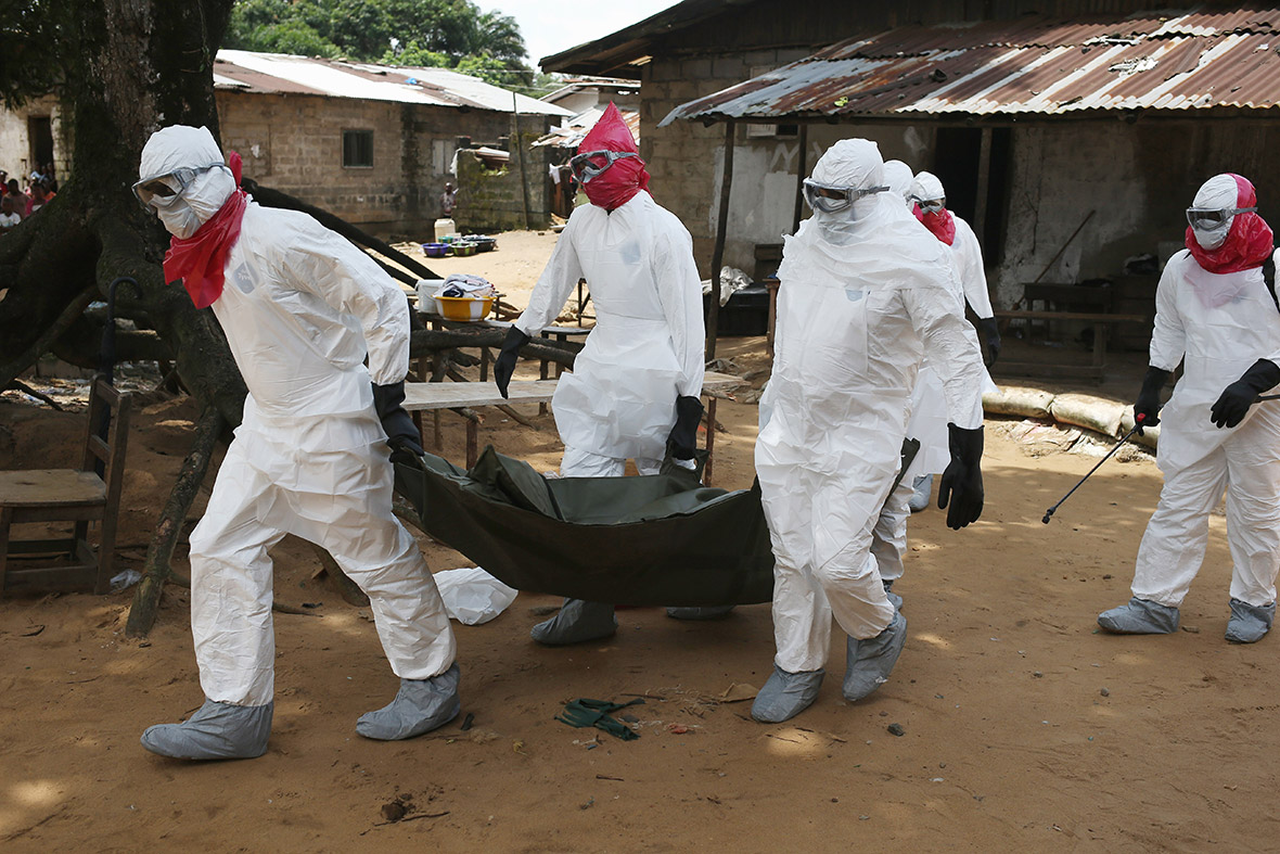 A burial team from the Liberian health department removes the body of a woman suspected to have died of the Ebola virus from her home in Monrovia
