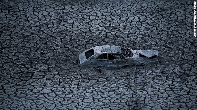 A car sits in the dried and cracked earth at the bottom of the Almaden Reservoir in San Jose, California, on January 28.