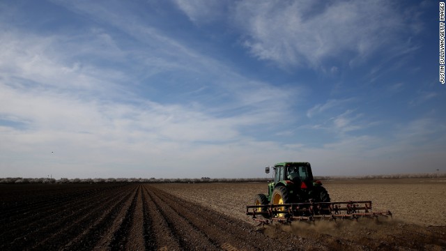A tractor plows a field in Firebaugh, California, on February 25. Almond farmer Barry Baker had 1,000 acres -- 20% -- of his almond trees removed because he didn't have access to enough water to keep them alive.