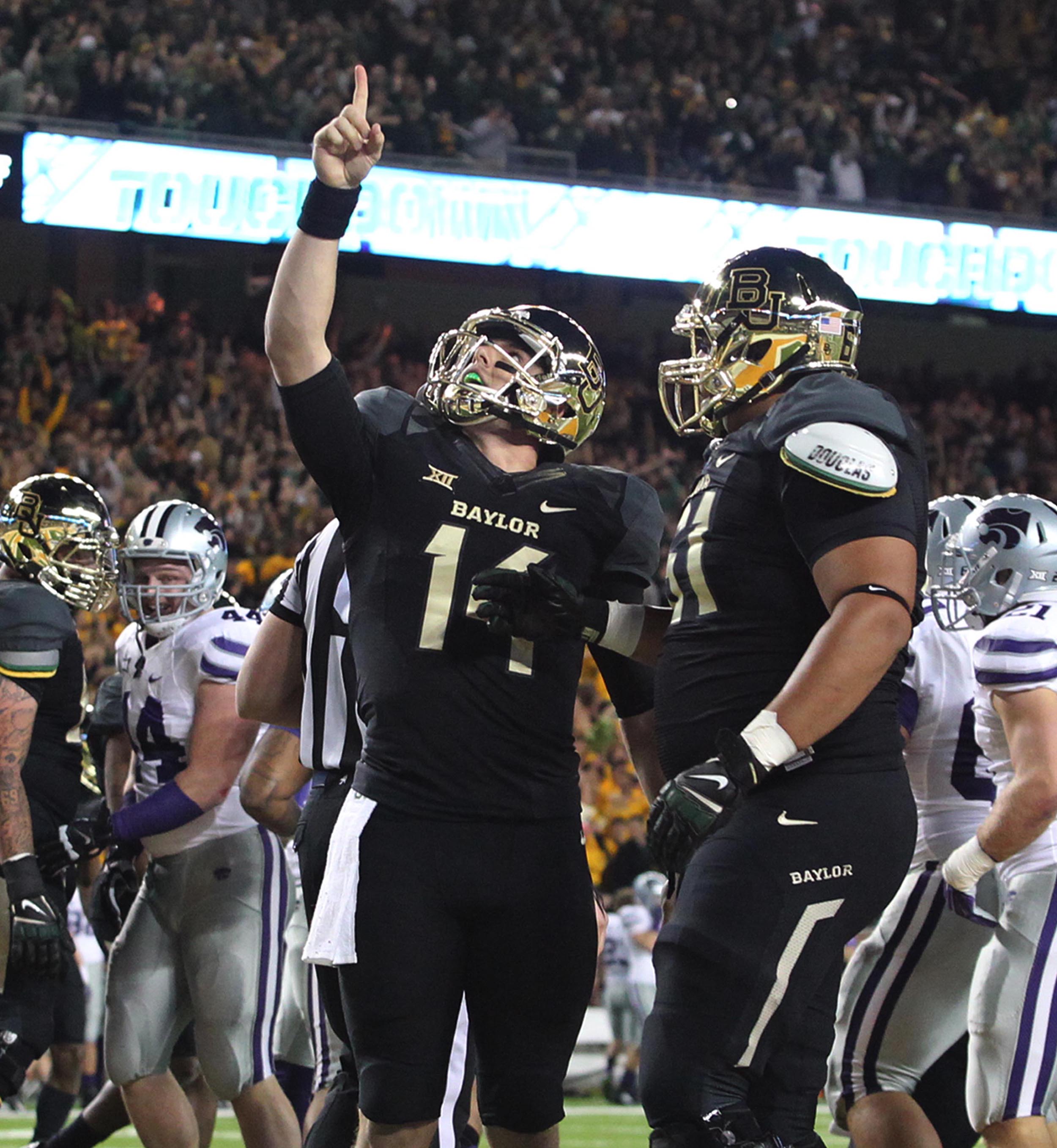 Baylor quarterback Bryce Petty (14) points upward with teammate offensive linesman Jarell Broxton (61), right, following his touchdown over Kansas State in the first half of NCAA college football game, Saturday, Dec. 6, 2014, in Waco, Texas. (AP Photo/Waco Tribune Herald, Jerry Larson)