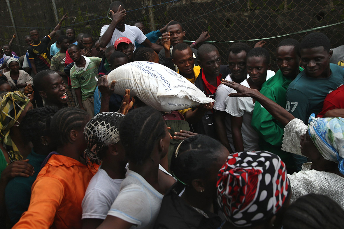 Residents of West Point receive rice, beans and cooking oil. They are forbidden from leaving the seaside slum, due to the Ebola outbreak in their community.