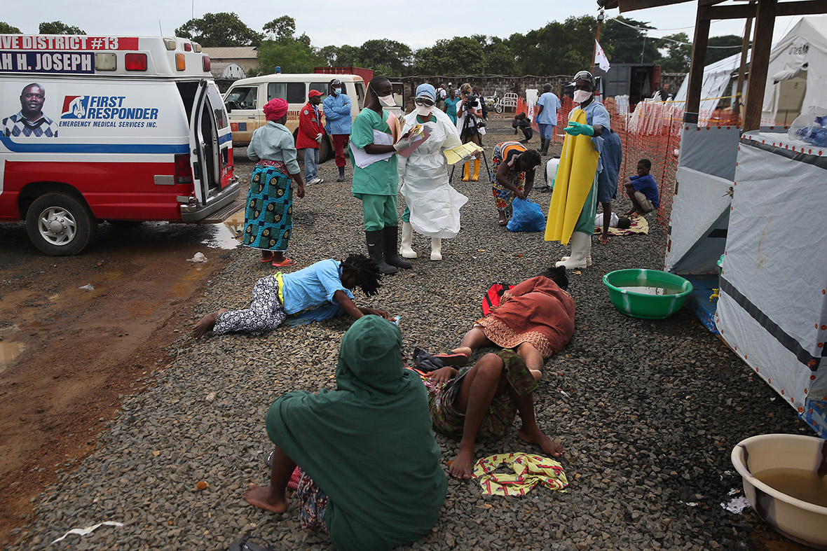People with suspected Ebola lie on the ground outside the Doctors Without Borders Ebola treatment centre after arriving by ambulance