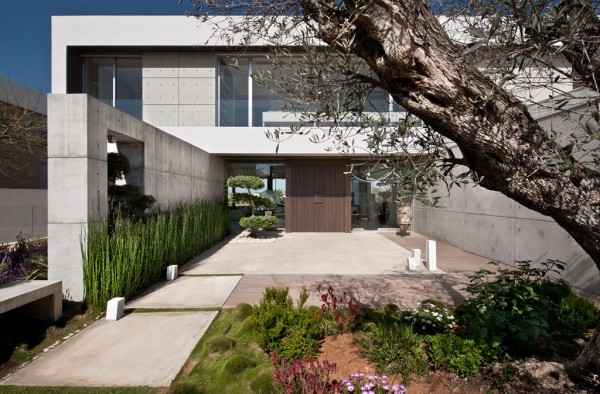 The home's entry is carefully landscaped with mosses and colorful, native plants.