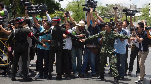 Thai soldiers and military police try to block media as Yingluck arrives at a military compound on May 23.